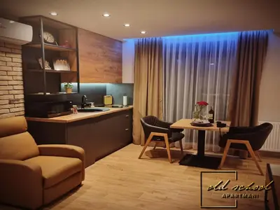 a kitchen and living room with a table and chairs at Old School Apartments in Banja Luka