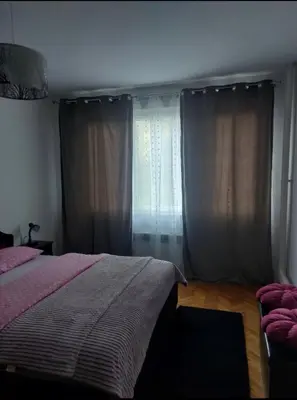 a bedroom with a bed and a window with curtains at Stan na dan Novi Grad in Bosanski Novi
