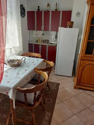 a kitchen with a table and chairs and a refrigerator at Stan na dan Novi Grad in Bosanski Novi