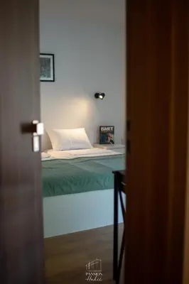 a bedroom with a bed with a green blanket at Pansion Hukić B&B in Tuzla