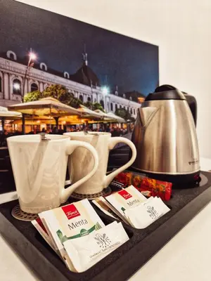 a tray with two cups and a tea kettle at Pansion Hukić B&B in Tuzla