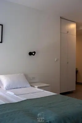 a bedroom with a bed and a white cabinet at Pansion Hukić B&B in Tuzla