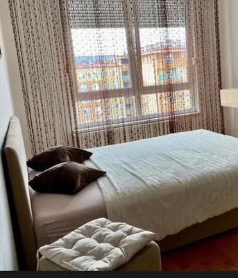 a bedroom with a large bed and a window at Apartmani Casa in Banja Luka