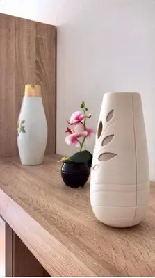two white vases sitting on a table with flowers at Apartmani Casa in Banja Luka