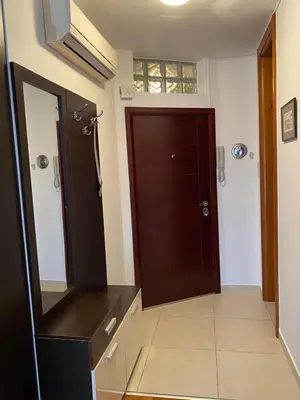 a bathroom with a mirror and a brown door at Apartmani Casa in Banja Luka