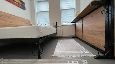 a bedroom with a large bed and a rug at Apartmani Aurora in Tuzla