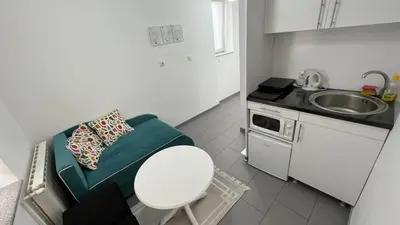 a small kitchen with a couch and a sink at Apartmani Aurora in Tuzla