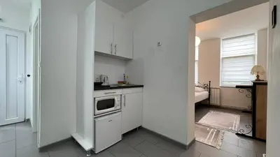 a white kitchen with a sink and a stove at Apartmani Aurora in Tuzla