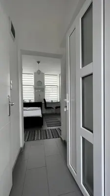 a hallway with a door leading to a bedroom at Apartmani Aurora in Tuzla
