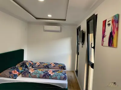 a small bedroom with a bed with a colorful comforter at Motel Platani Kotor Varoš in Kotorište