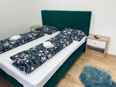a bed with black and white comforter and pillows at Motel Platani Kotor Varoš in Kotorište