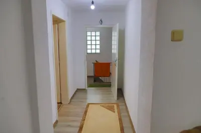 a hallway with white walls and a table in a room at Apartman Bucko in Bihać