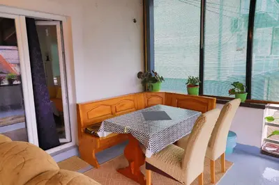 a table and chairs in a room with a window at Apartman Bucko in Bihać