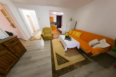 a living room with an orange couch and a table at Apartman Bucko in Bihać