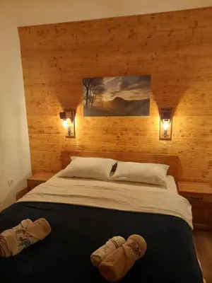 a bedroom with a large bed with two slippers on it at Apartman Milekic in Mrkonjić Grad