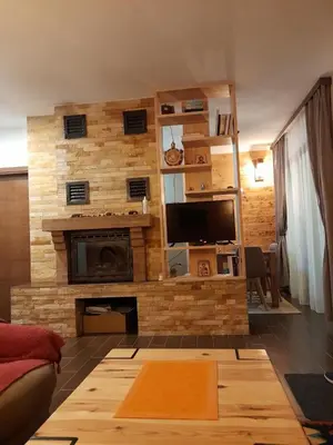 a living room with a stone wall with a fireplace at Apartman Milekic in Mrkonjić Grad