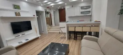 a living room with a couch and a tv and a kitchen at Apartman Dona in Banja Luka