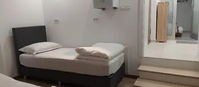 a small bedroom with a bed and a mirror at Apartman Dona in Banja Luka
