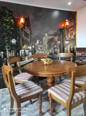 a table and chairs with a painting of a city at Home of nature - kuća prirode in Odžak