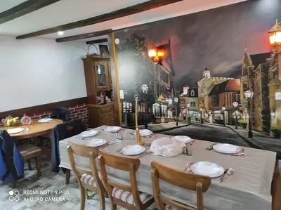 a table in a restaurant with a painting on the wall at Home of nature - kuća prirode in Odžak