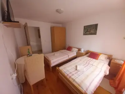 a small room with two beds and a table at Soba Dujaković in Banja Vrućica