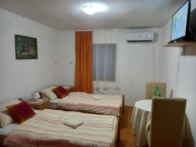 a room with two beds and a television in it at Soba Dujaković in Banja Vrućica