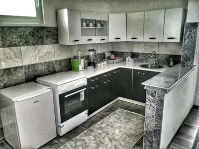 a kitchen with a white refrigerator and a dishwasher at Apartman Visoko-Oaza mira in Visoko