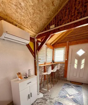 a kitchen with a refrigerator and chairs in a room at Apartman Visoko-Oaza mira in Visoko