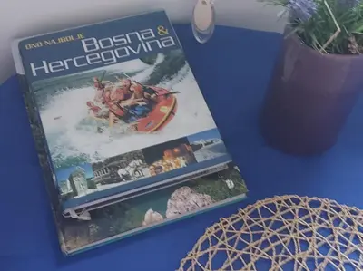a book sitting on a table next to a vase at Indy in Travnik