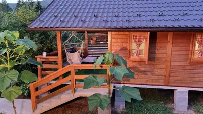 a log cabin with a porch and a porch swing at Holiday Home SAJRA in Kulen Vakuf