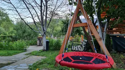 a red swing in a garden with a ladder at Holiday Home SAJRA in Kulen Vakuf