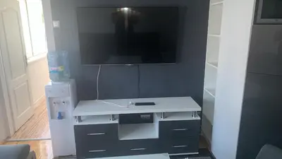 a white desk with a tv on a wall at Stan na dan Banovići in Banovići