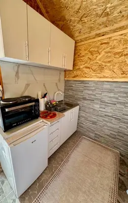 a small kitchen with white cabinets and a stove at Oaza mira Visoko in Visoko