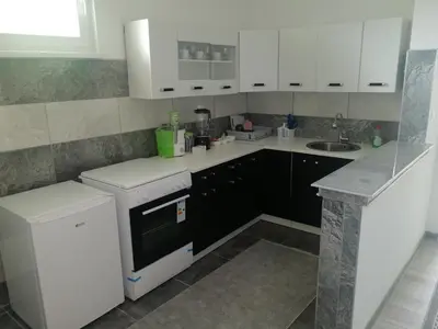 a kitchen with white cabinets and a sink at Oaza mira Visoko in Visoko