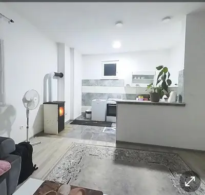 a living room with a kitchen and a stove at Oaza mira Visoko in Visoko