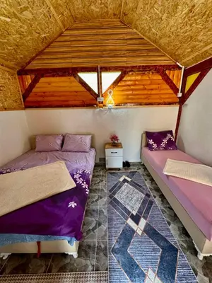 two beds in a room with a roof at Oaza mira Visoko in Visoko