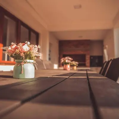 a long wooden table with flowers in a room at 