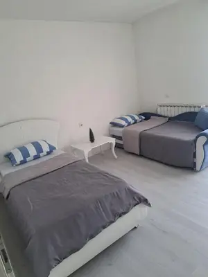 a bedroom with two beds and a table in it at Garden- pool apartman in Petrovice Donje