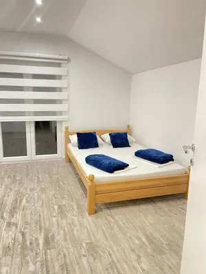 a bedroom with a bed with blue pillows and a window at Una Bihac 4 in Bihać
