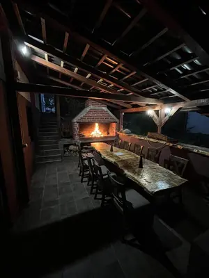 a dining room with a table and chairs and a fireplace at Vikendica Konstantin Slatina-Banja Luka in Laktaši