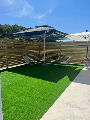 a patio with a table and chairs and an umbrella at Vikendica Konstantin Slatina-Banja Luka in Laktaši