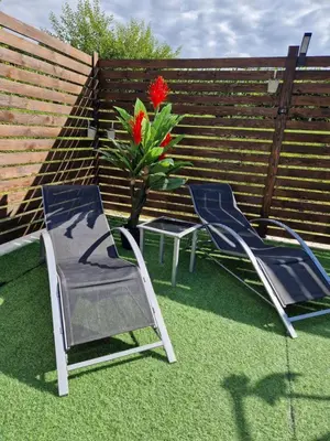 two chairs and a table and a vase with a flower at Vikendica Konstantin Slatina-Banja Luka in Laktaši