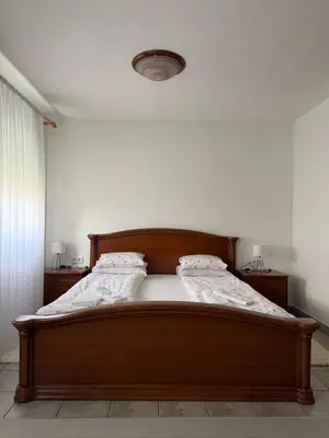 a bedroom with a wooden bed with two pillows at Sobe kod bolnice Paprikovac in Banja Luka