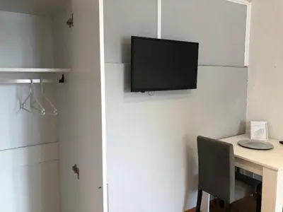 a room with a desk and a television on a wall at Sobe kod bolnice Paprikovac in Banja Luka
