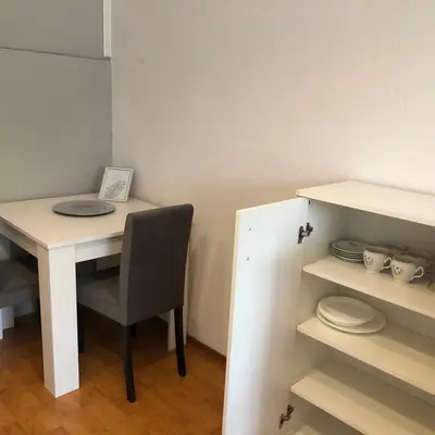 a room with a table and a chair and shelves at Sobe kod bolnice Paprikovac in Banja Luka
