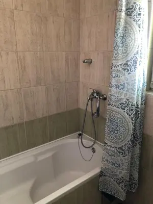 a bathroom with a bath tub with a shower curtain at Sobe kod bolnice Paprikovac in Banja Luka