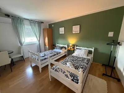 two beds in a room with green walls at Sobe kod bolnice Paprikovac in Banja Luka