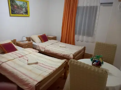 a room with two beds and a table and chairs at Soba Dujaković in Banja Vrućica