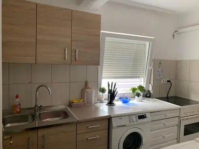 a kitchen with a sink and a washing machine at Anja Apartman in Bosanski Šamac