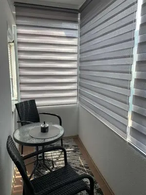 a table and two chairs in a room with a window at Anja Apartman in Bosanski Šamac